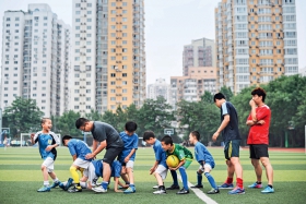 教练通过游戏训练小球员的身体灵活性。（魏尧）.JPG